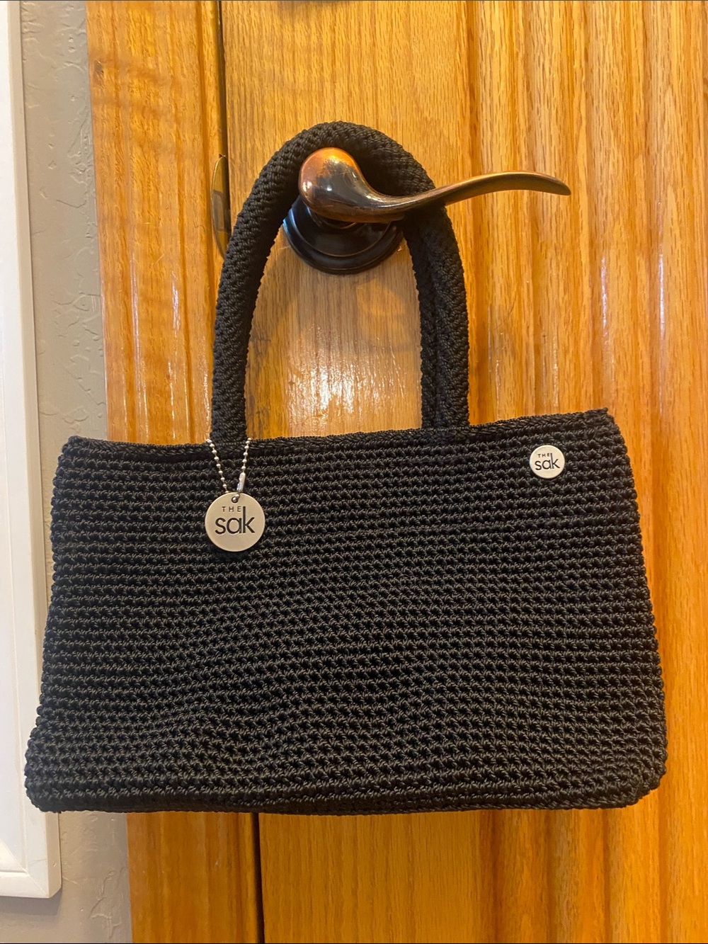 The Sak Black Crochet Mini Tote with Signature Charm & Silver hardware